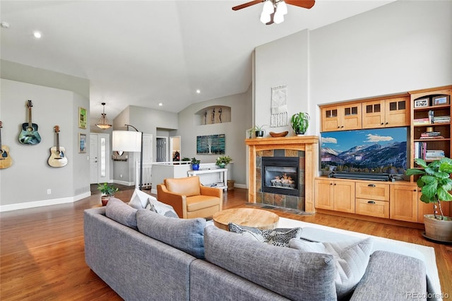 6776 Salvia Ct, Arvada, CO 80007 - living room featuring lofted ceiling, wood finished floors, ceiling fan, a tile fireplace, and baseboards