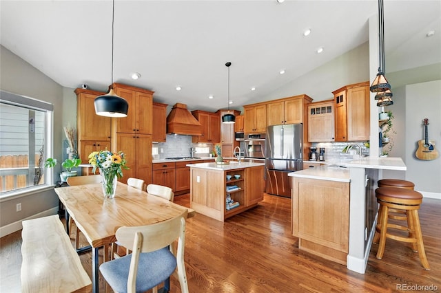 6776 Salvia Ct, Arvada, CO 80007 - kitchen featuring appliances with stainless steel finishes, custom exhaust hood, wood finished floors, light countertops, and lofted ceiling