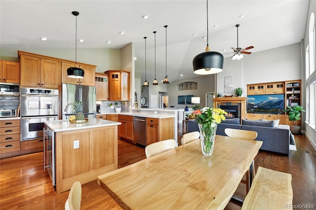 6776 Salvia Ct, Arvada, CO 80007 - kitchen with stainless steel appliances, open floor plan, a peninsula, light countertops, and a ceiling fan