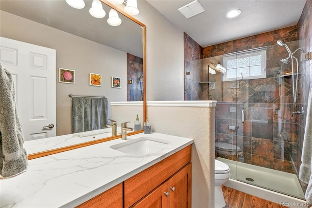 6776 Salvia Ct, Arvada, CO 80007 - bathroom with toilet, vanity, a stall shower, wood finished floors, and recessed lighting