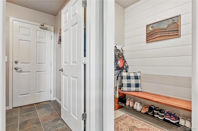 6776 Salvia Ct, Arvada, CO 80007 - mudroom featuring dark stone finish floors, wooden walls, and baseboards
