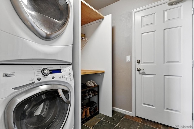 6776 Salvia Ct, Arvada, CO 80007 - laundry room with estacked washer and dryer, baseboards, and dark stone finish flooring