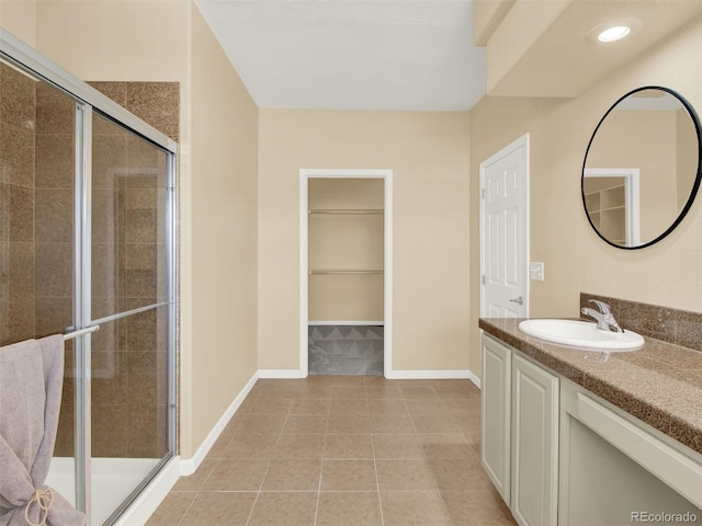 bathroom featuring an enclosed shower, tile patterned floors, and vanity