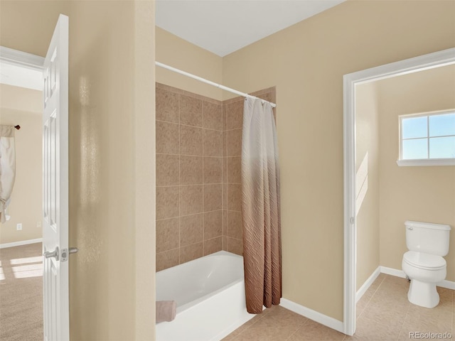 bathroom featuring toilet, tile patterned flooring, and shower / tub combo with curtain