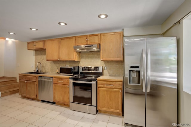 kitchen featuring sink, stainless steel appliances, decorative backsplash, and light tile patterned floors