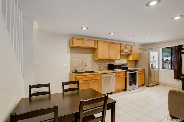 kitchen featuring stainless steel appliances, tasteful backsplash, sink, light tile patterned floors, and light brown cabinetry