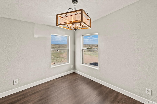 9765LAPINTURAPT La Pintura Pt, Fountain, CO 80817 - unfurnished dining area with a chandelier, dark wood-style flooring, baseboards, a textured wall, and a textured ceiling