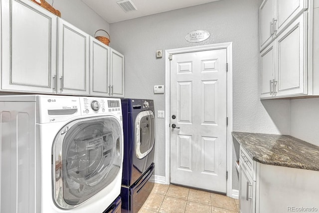 washroom with light tile patterned flooring, cabinets, and separate washer and dryer