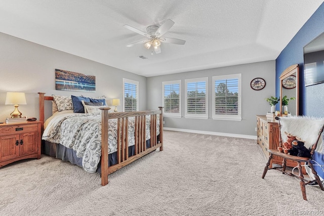 bedroom featuring ceiling fan, light colored carpet, and a textured ceiling