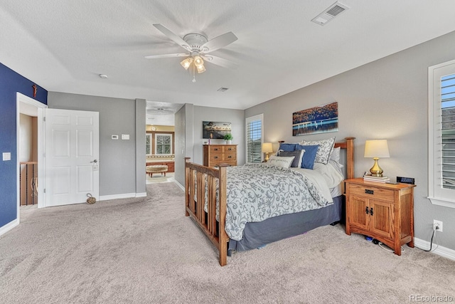 carpeted bedroom with ceiling fan and a textured ceiling