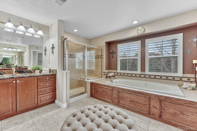 bathroom featuring tile patterned floors, vanity, plus walk in shower, and a textured ceiling