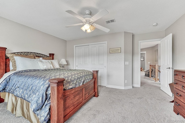 bedroom with light carpet, a textured ceiling, ceiling fan, and a closet