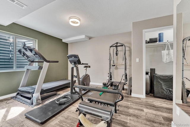 workout room with wood-type flooring and a textured ceiling