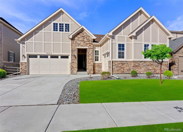 tudor home with a garage and a front yard