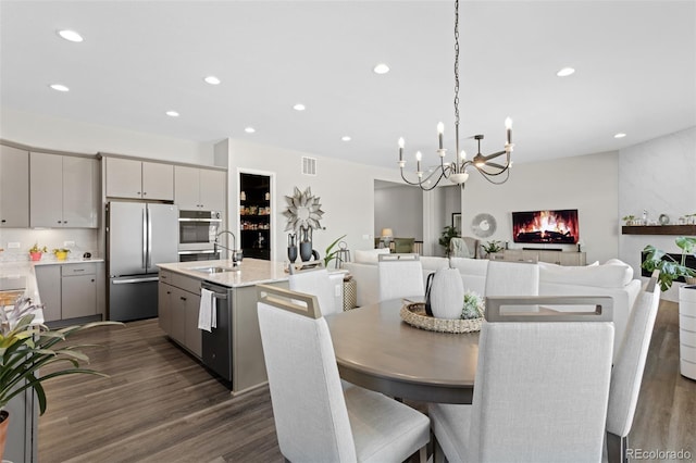 dining area with a large fireplace, dark hardwood / wood-style floors, and sink