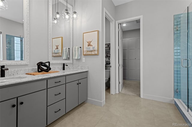 bathroom featuring a shower with shower door, vanity, and toilet