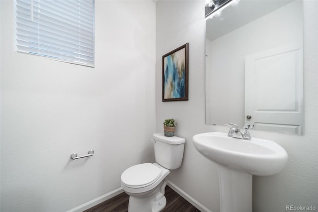 bathroom featuring hardwood / wood-style flooring and toilet