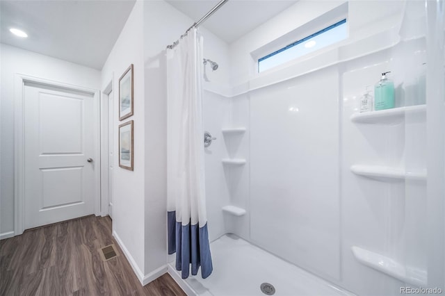 bathroom with walk in shower and hardwood / wood-style floors