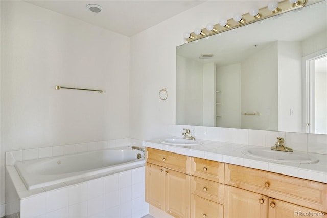 bathroom with double vanity, a sink, and a bath