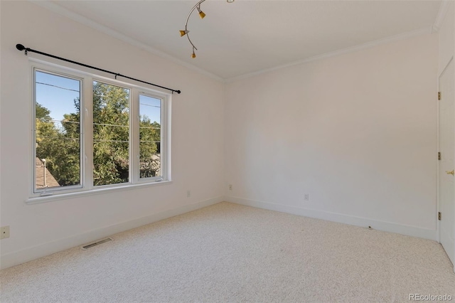 carpeted empty room with visible vents, baseboards, and crown molding