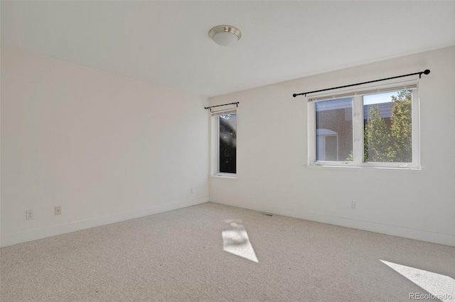 carpeted spare room featuring baseboards