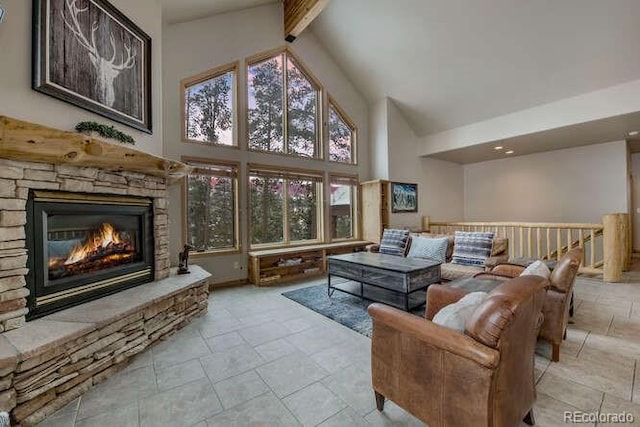 living area with high vaulted ceiling, a fireplace, stone tile flooring, and beam ceiling