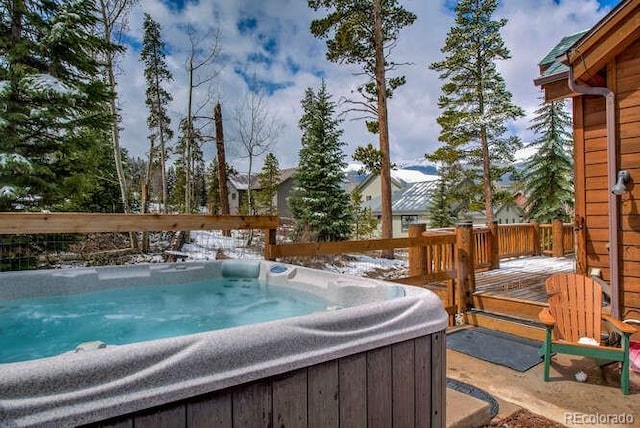 view of swimming pool with a hot tub and a wooden deck