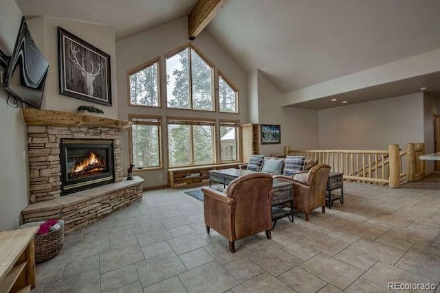 living room featuring high vaulted ceiling, a stone fireplace, and beamed ceiling