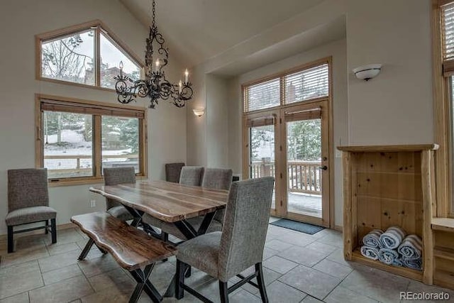 dining area with high vaulted ceiling, healthy amount of natural light, a chandelier, and french doors