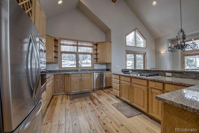 kitchen with appliances with stainless steel finishes, high vaulted ceiling, open shelves, a sink, and light wood-style flooring
