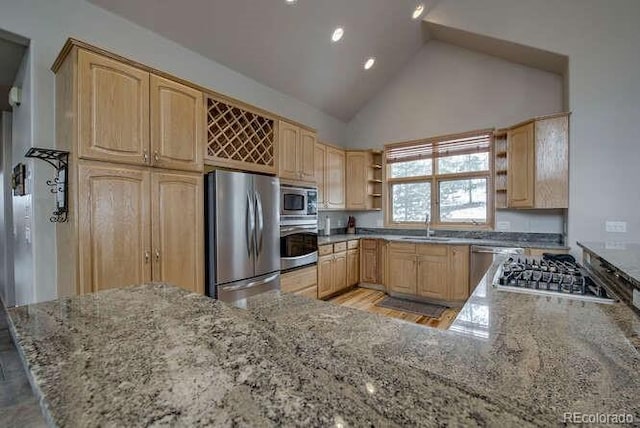 kitchen with stainless steel appliances, light brown cabinetry, open shelves, light stone countertops, and a sink