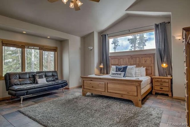 bedroom featuring lofted ceiling, baseboards, stone finish flooring, and ceiling fan