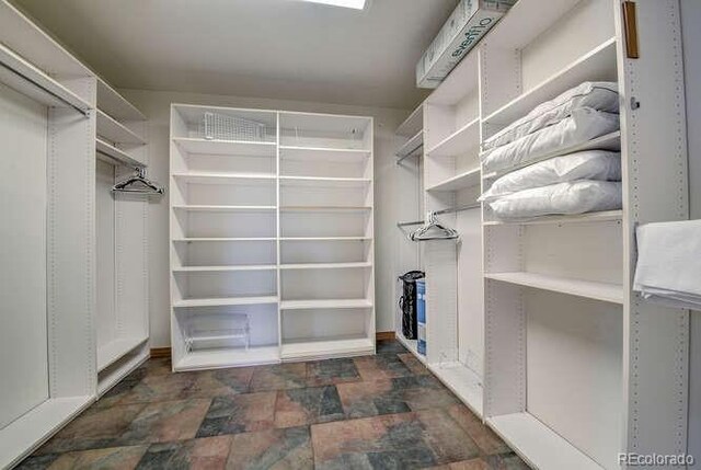 spacious closet with stone finish flooring