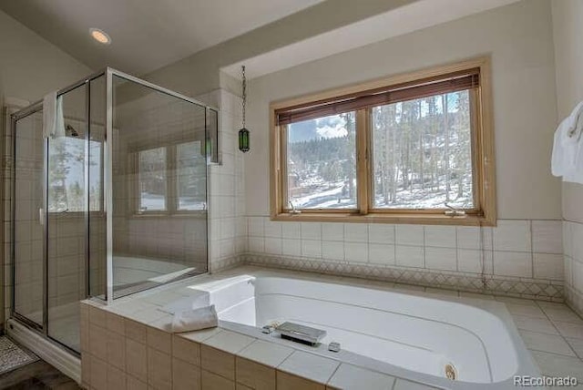 full bath with a shower stall and a garden tub