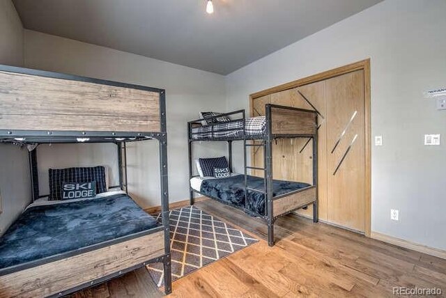 bedroom with wood finished floors and baseboards
