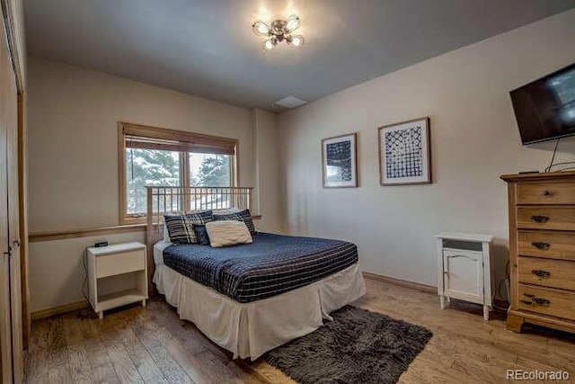 bedroom with wood finished floors and baseboards