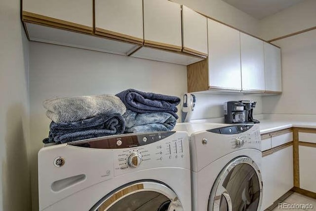 washroom featuring washing machine and dryer and cabinet space