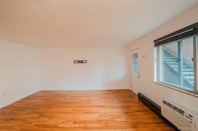 558 N Washington St Unit 103, Denver, CO 80203 - spare room featuring ornamental molding, light wood-type flooring, and a wall unit AC