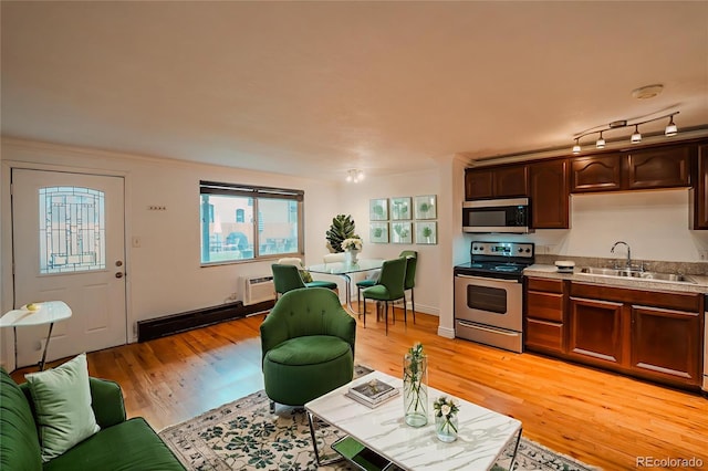 558 N Washington St Unit 103, Denver, CO 80203 - living area featuring light wood-style floors, a baseboard radiator, and a wall mounted air conditioner