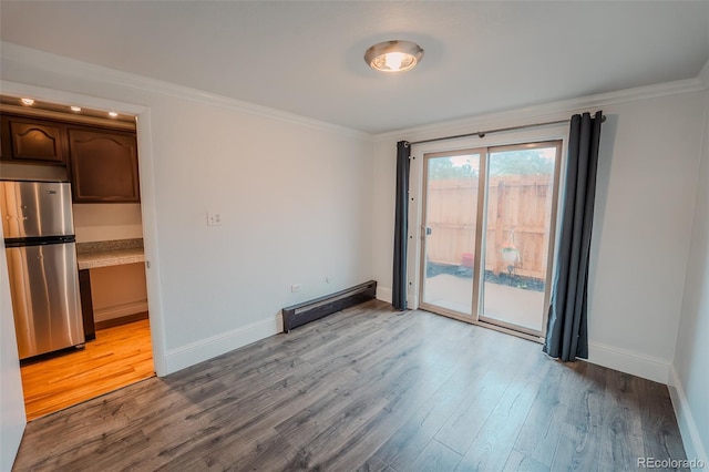 558 N Washington St Unit 103, Denver, CO 80203 - unfurnished room with a baseboard radiator, ornamental molding, and wood finished floors
