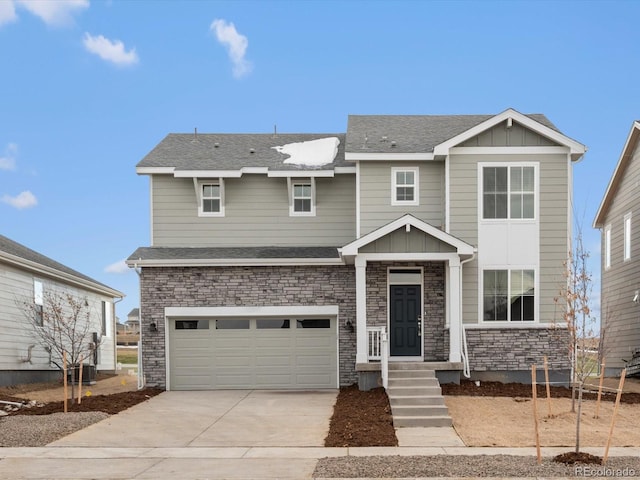 view of front of home with stone siding, board and batten siding, concrete driveway, and a shingled roof