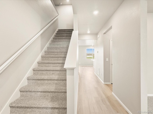 stairway with baseboards and wood finished floors