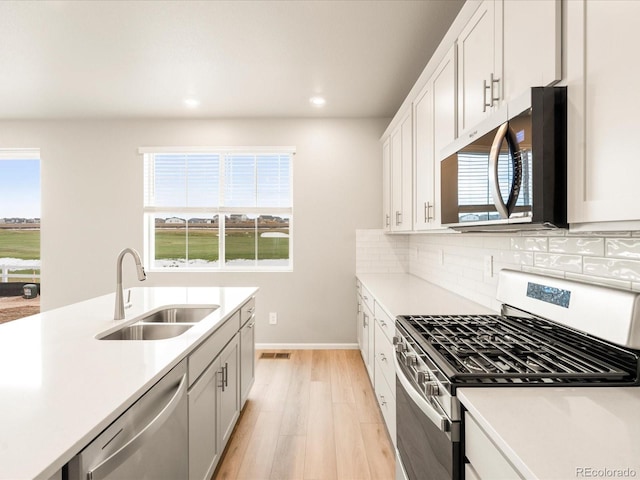 kitchen featuring a sink, stainless steel appliances, and light countertops