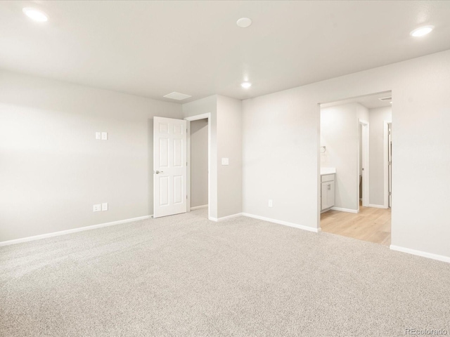 unfurnished room with light carpet, recessed lighting, and baseboards