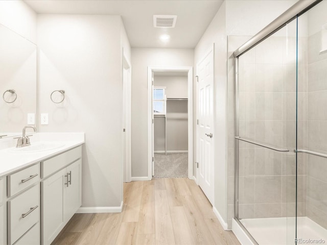 full bath featuring visible vents, a stall shower, vanity, and wood finished floors