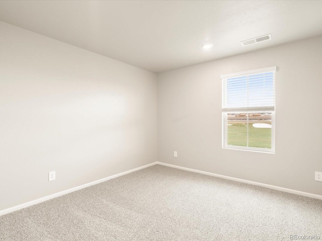 empty room featuring carpet flooring, baseboards, and visible vents