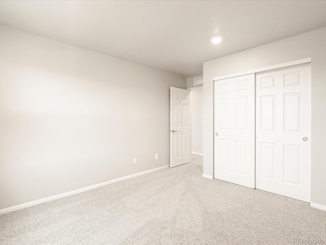 unfurnished bedroom featuring a closet, baseboards, and carpet