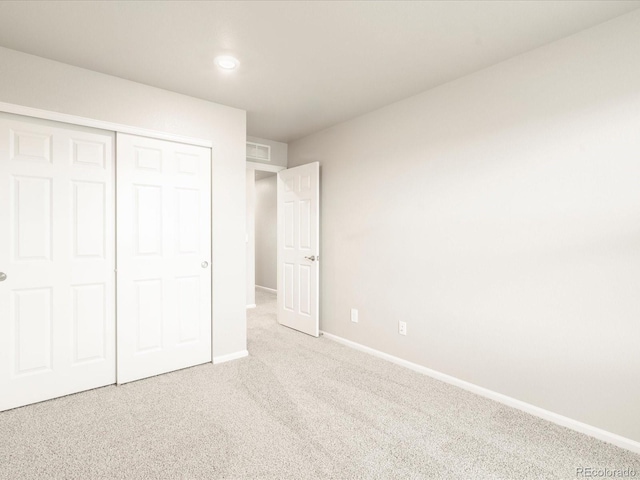 unfurnished bedroom featuring a closet, carpet flooring, visible vents, and baseboards