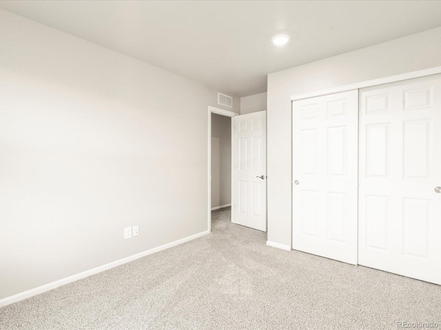 unfurnished bedroom with visible vents, baseboards, carpet, and a closet