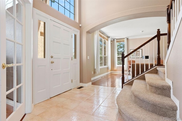 5120 Langdale Way, Colorado Springs, CO 80906 - entrance foyer featuring arched walkways, plenty of natural light, light tile patterned floors, stairs, and crown molding